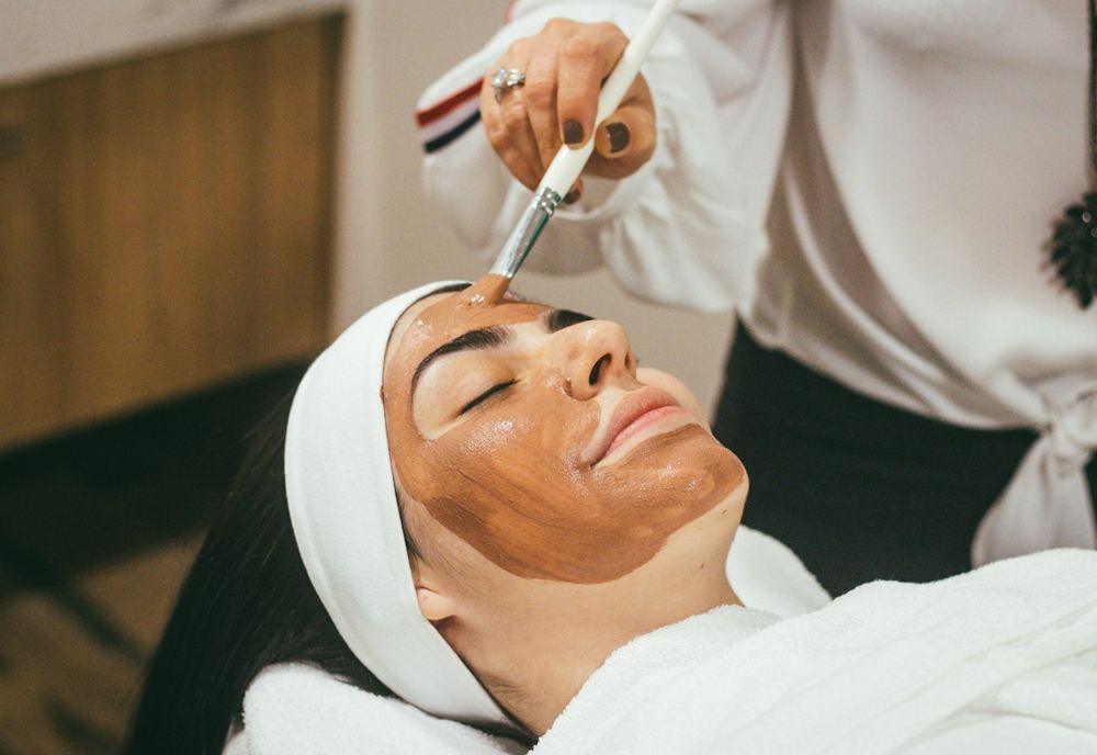 Clinician applying a facial mask during a skincare treatment